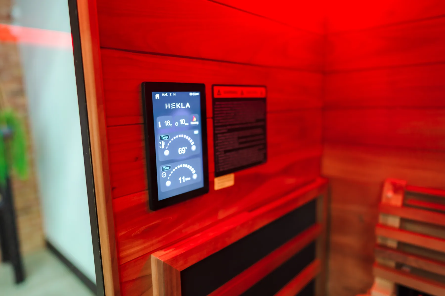 Infrarotkabine – Touchdisplay im rot beleuchteten Innenraum